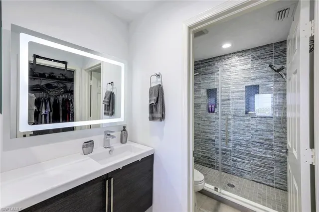 a bathroom with a shower sink and mirror