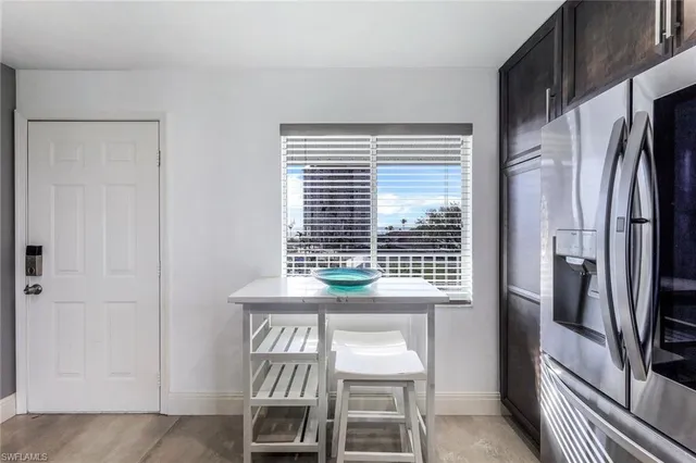 a kitchen with stainless steel appliances a refrigerator a table and chairs