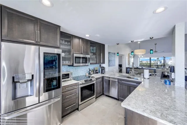 a kitchen with stainless steel appliances granite countertop a sink stove and refrigerator