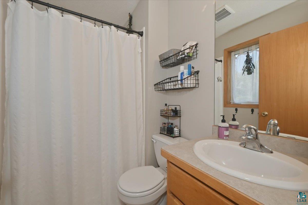 47 Amy Lane Esko, MN 55733 - Photo 20 of 33 Bathroom featuring a vanity with an integrated sink, laminate countertop, and wood-finish cabinetry
