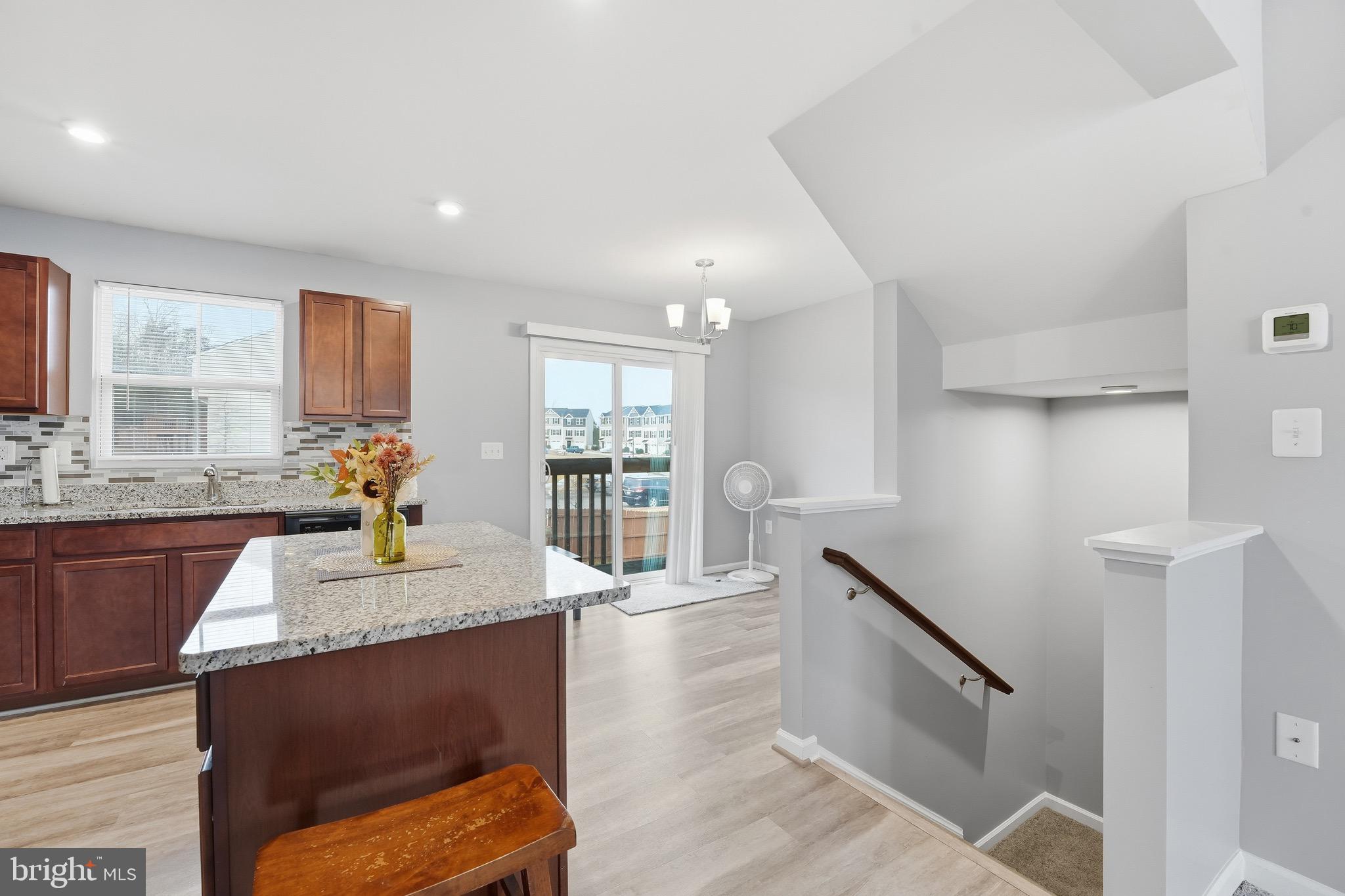 35209 Sara Court Locust Grove, VA 22508 - Photo 19 of 37 a large kitchen with granite countertop a stove a sink a refrigerator and blue cabinets with wooden floor