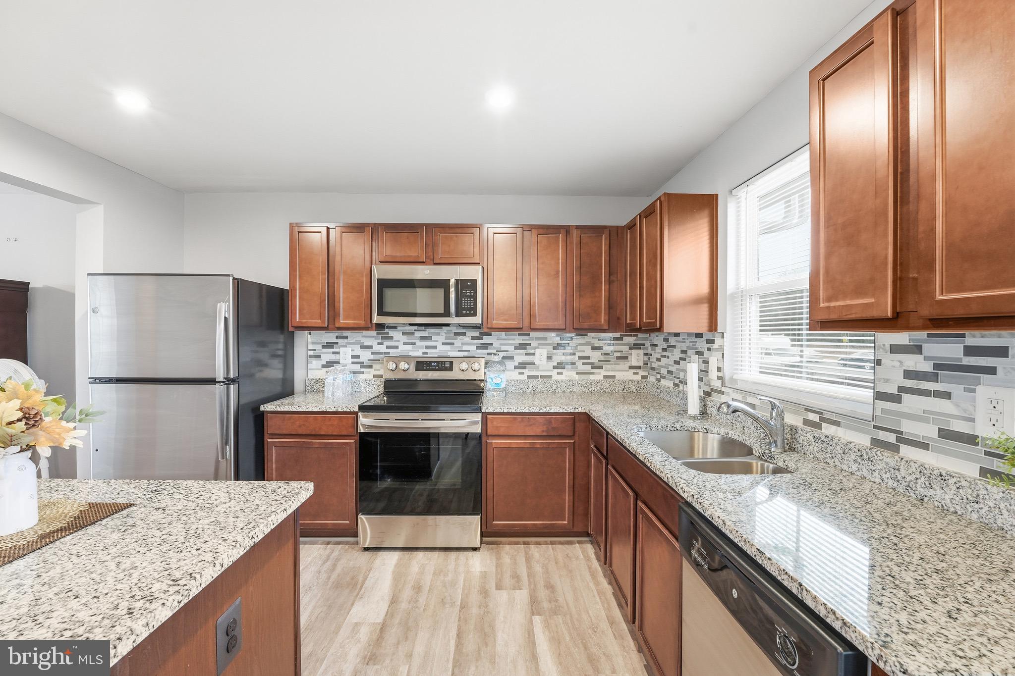 35209 Sara Court Locust Grove, VA 22508 - Photo 2 of 37 a kitchen with stainless steel appliances granite countertop a sink stove microwave and refrigerator