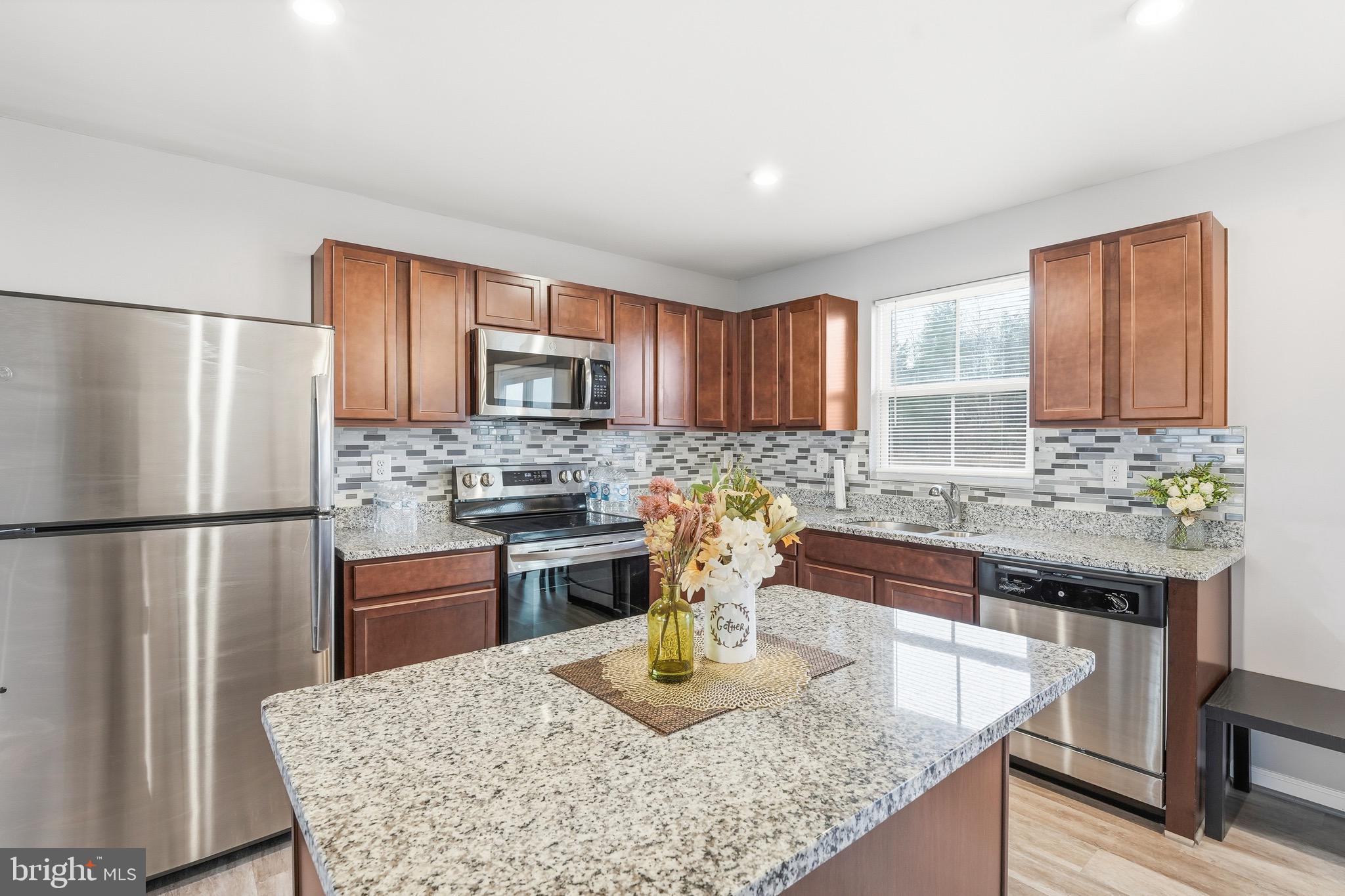 35209 Sara Court Locust Grove, VA 22508 - Photo 4 of 37 a kitchen with refrigerator a stove a sink dishwasher and microwave