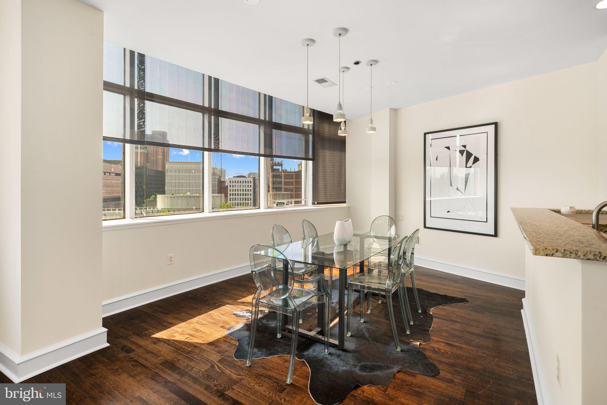 201-59 North 8th Street, Unit 603 Philadelphia, PA 19106 - Photo 11 of 35 a dining room with wooden floor a chandelier a glass table and chairs