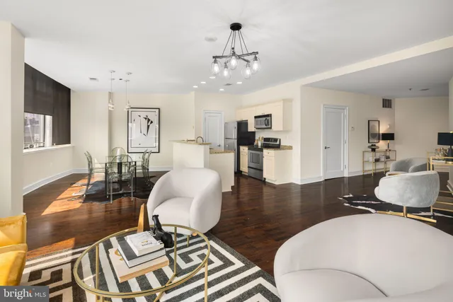 a living room with furniture a dining table and a chandelier