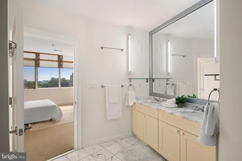a bathroom with a granite countertop sink a mirror and shower