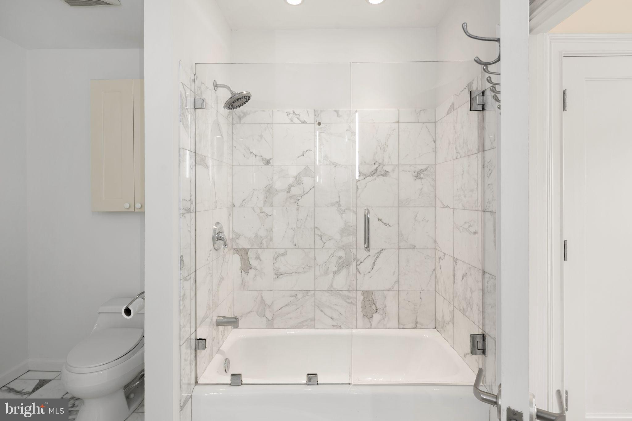 201-59 North 8th Street, Unit 603 Philadelphia, PA 19106 - Photo 22 of 35 a bathroom with a bathtub shower and toilet