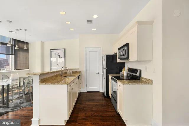 a kitchen with granite countertop a sink stove and refrigerator