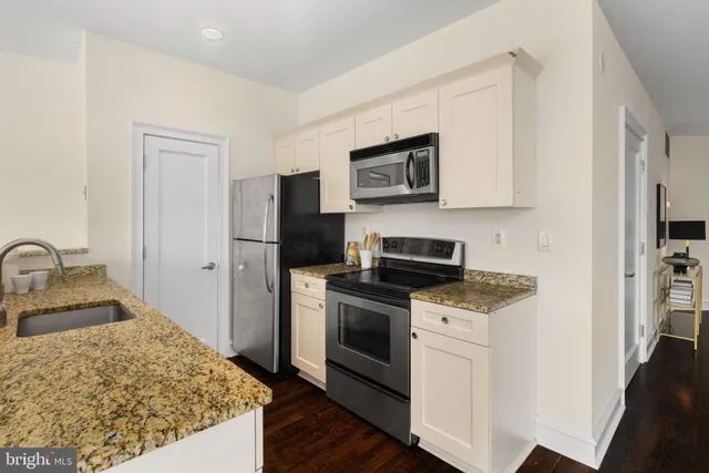 a kitchen with stainless steel appliances granite countertop a refrigerator stove top oven and sink