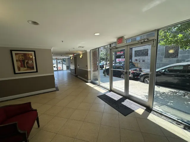 a living room with furniture a flat screen tv and a floor to ceiling window