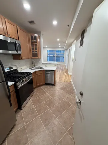 a kitchen with stainless steel appliances granite countertop a sink stove and cabinets
