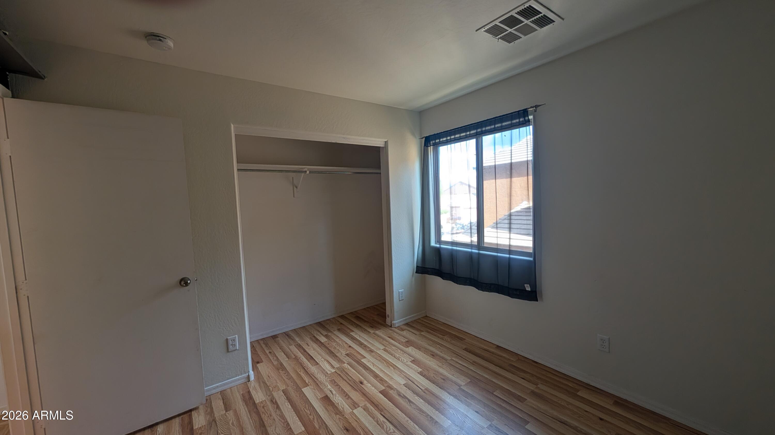 13229 East Primrose Lane Florence, AZ 85132 - Photo 11 of 11 a view of an empty room with wooden floor and a window