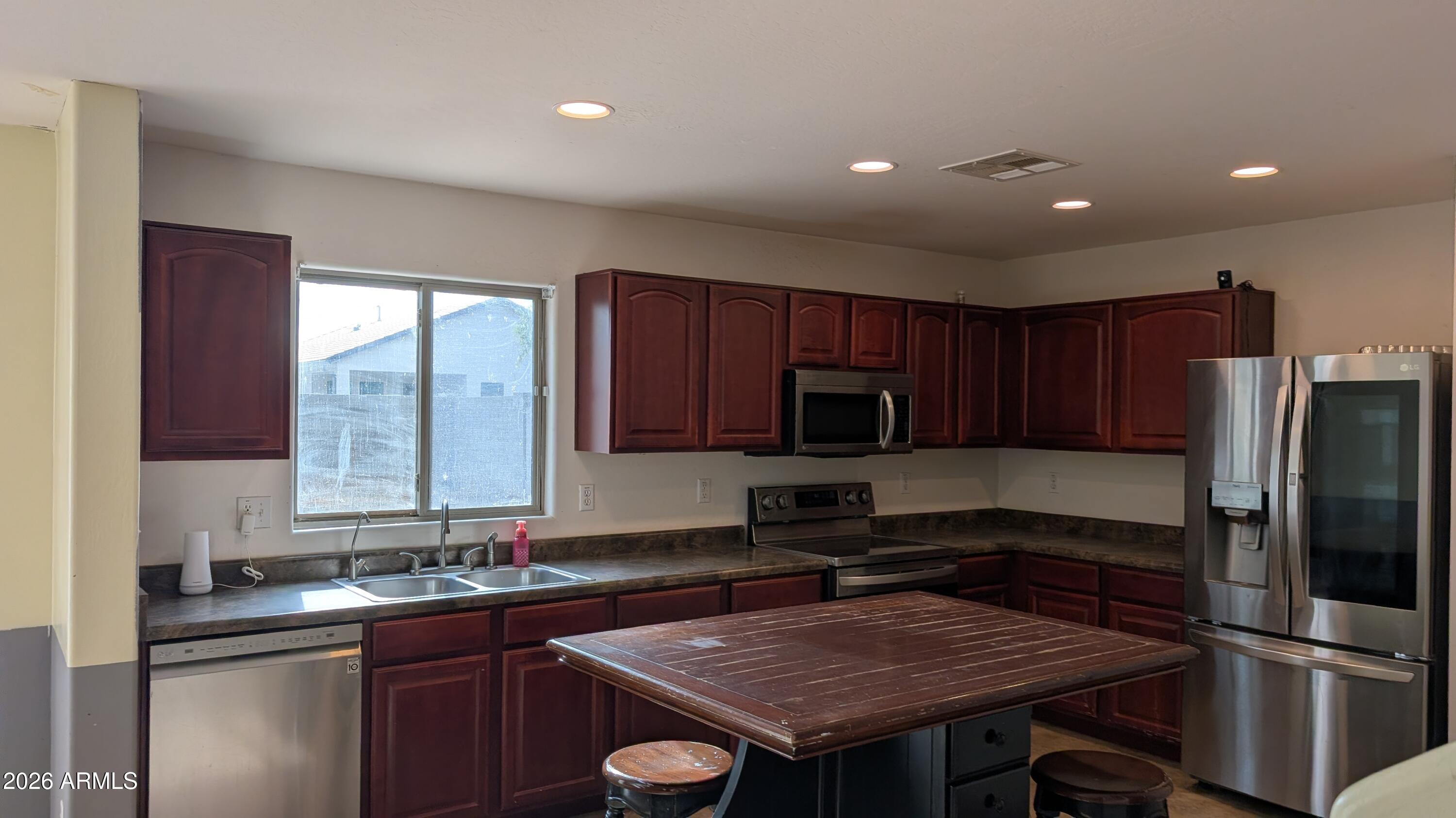 13229 East Primrose Lane Florence, AZ 85132 - Photo 3 of 11 a kitchen with a sink a microwave a refrigerator and cabinets