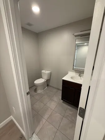 a bathroom with a toilet a sink a vanity and mirror