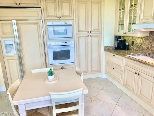a kitchen with stainless steel appliances a white table and chairs