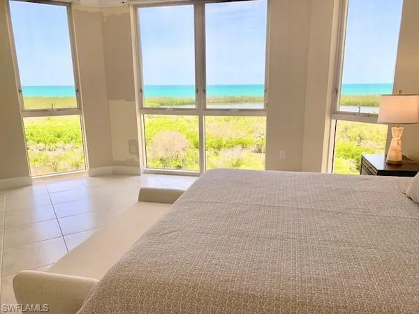 a bedroom with a bed and a large window