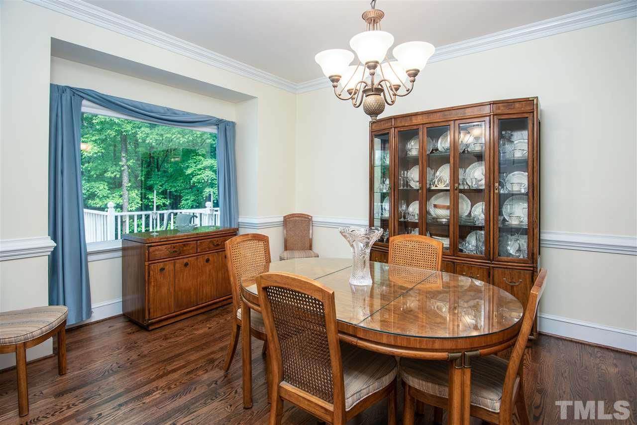 809 Ascot Lane Raleigh, NC 27615 - Photo 4 of 25 a view of a dining room with furniture a chandelier and wooden floor