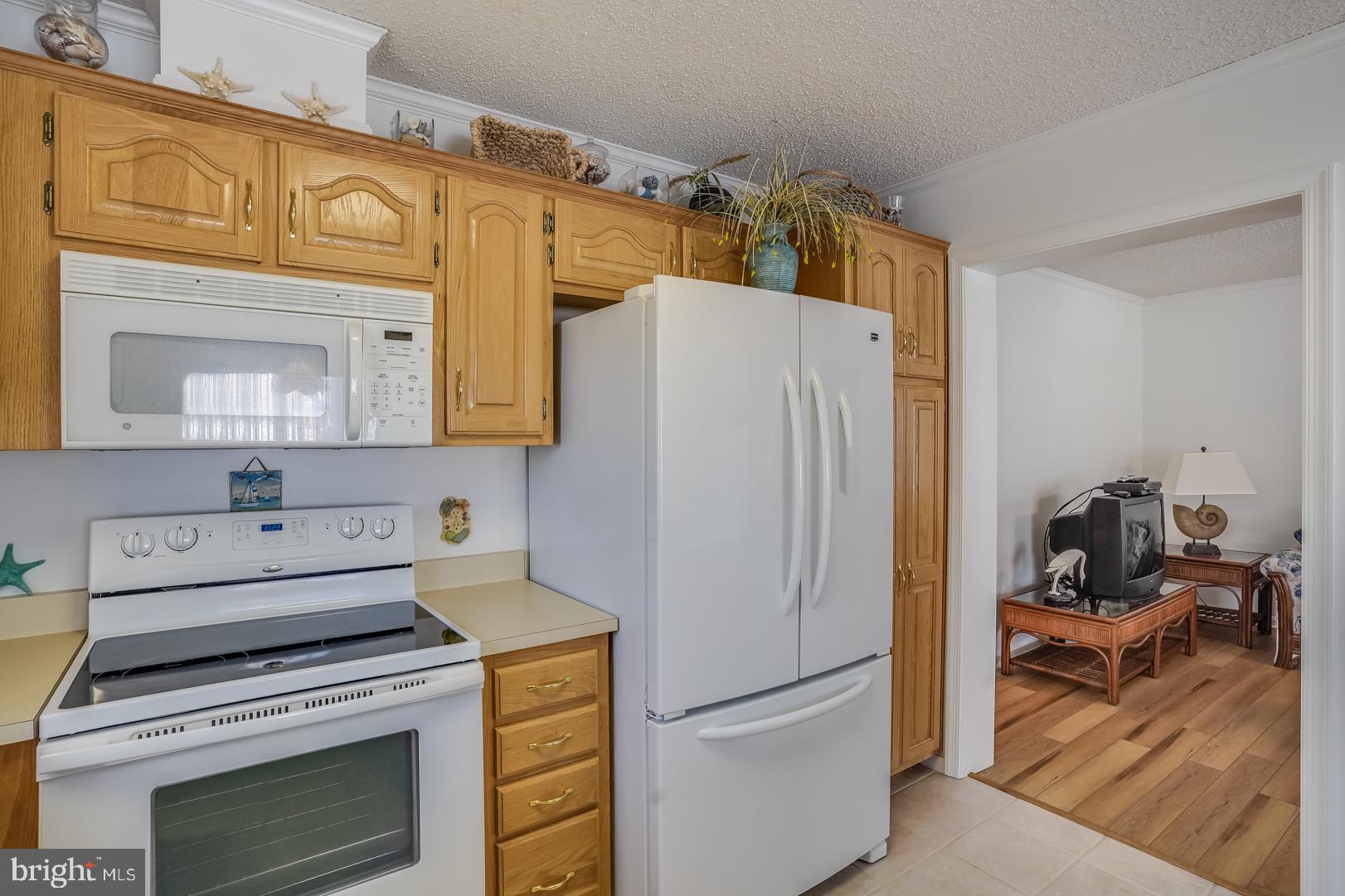 13702 Sailing Road Ocean City, MD 21842 - Photo 12 of 32 a kitchen with a refrigerator and a stove top oven