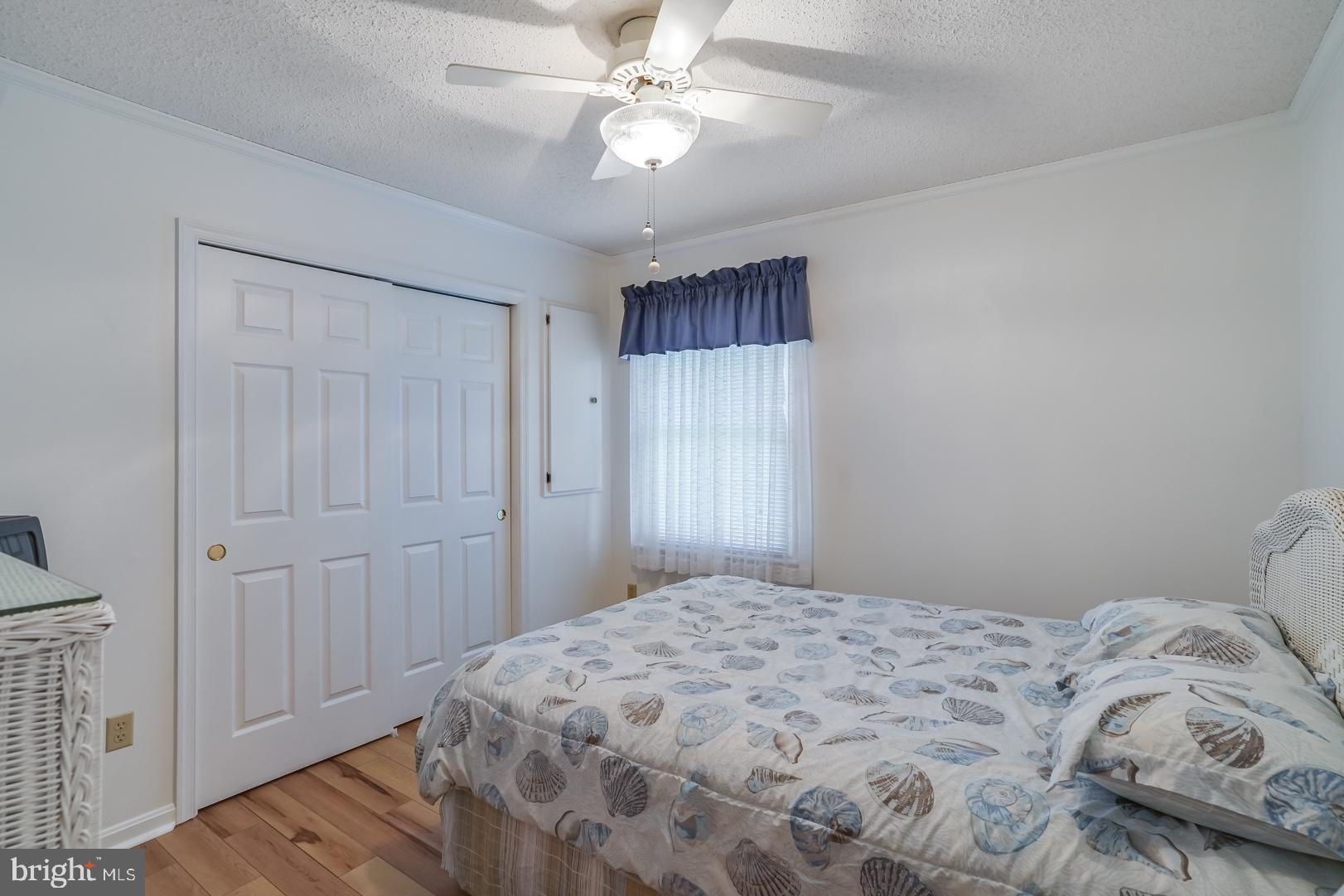 13702 Sailing Road Ocean City, MD 21842 - Photo 19 of 32 a bedroom with a bed and a chandelier