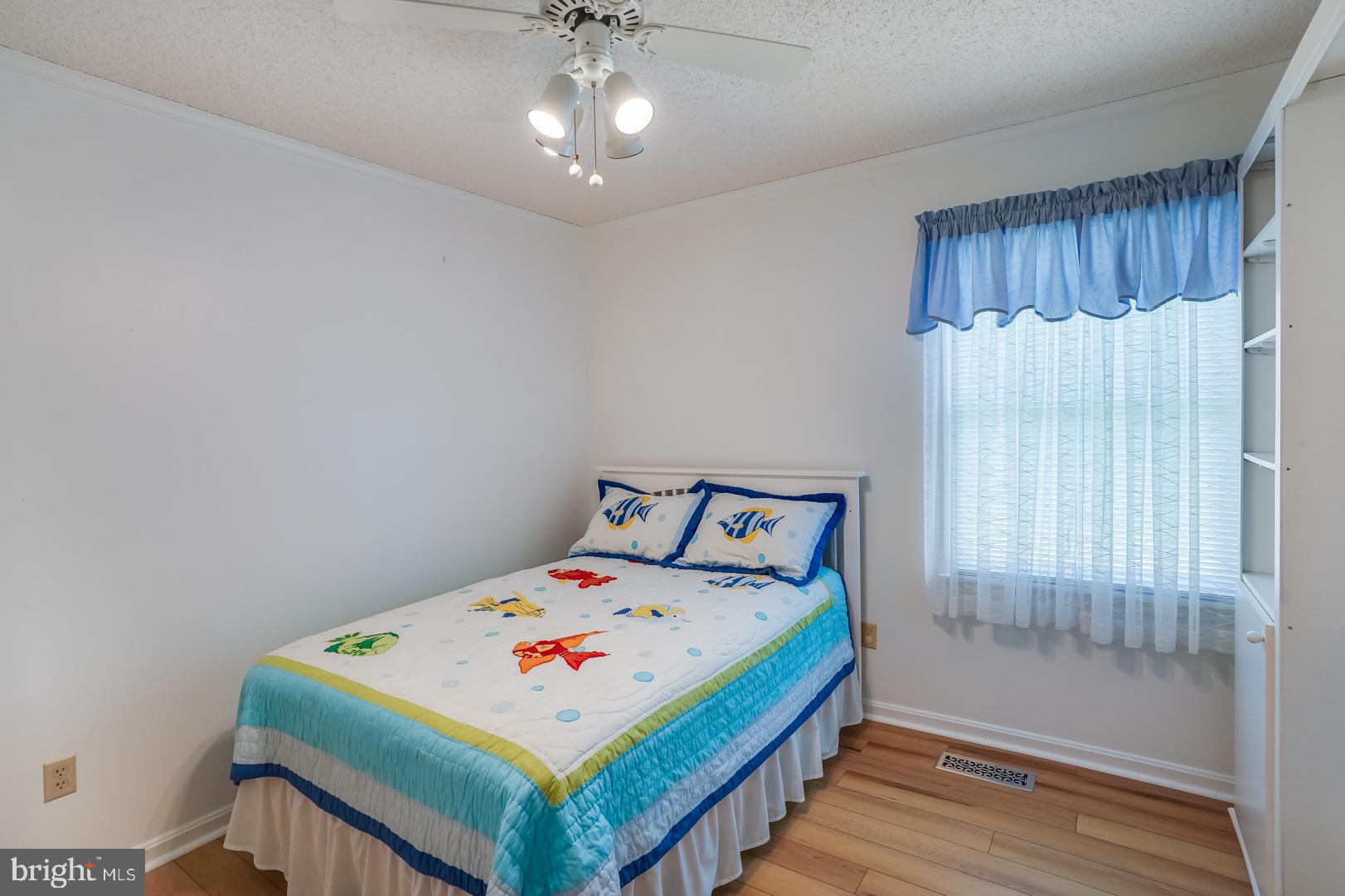 13702 Sailing Road Ocean City, MD 21842 - Photo 21 of 32 a bedroom with a bed and a chandelier