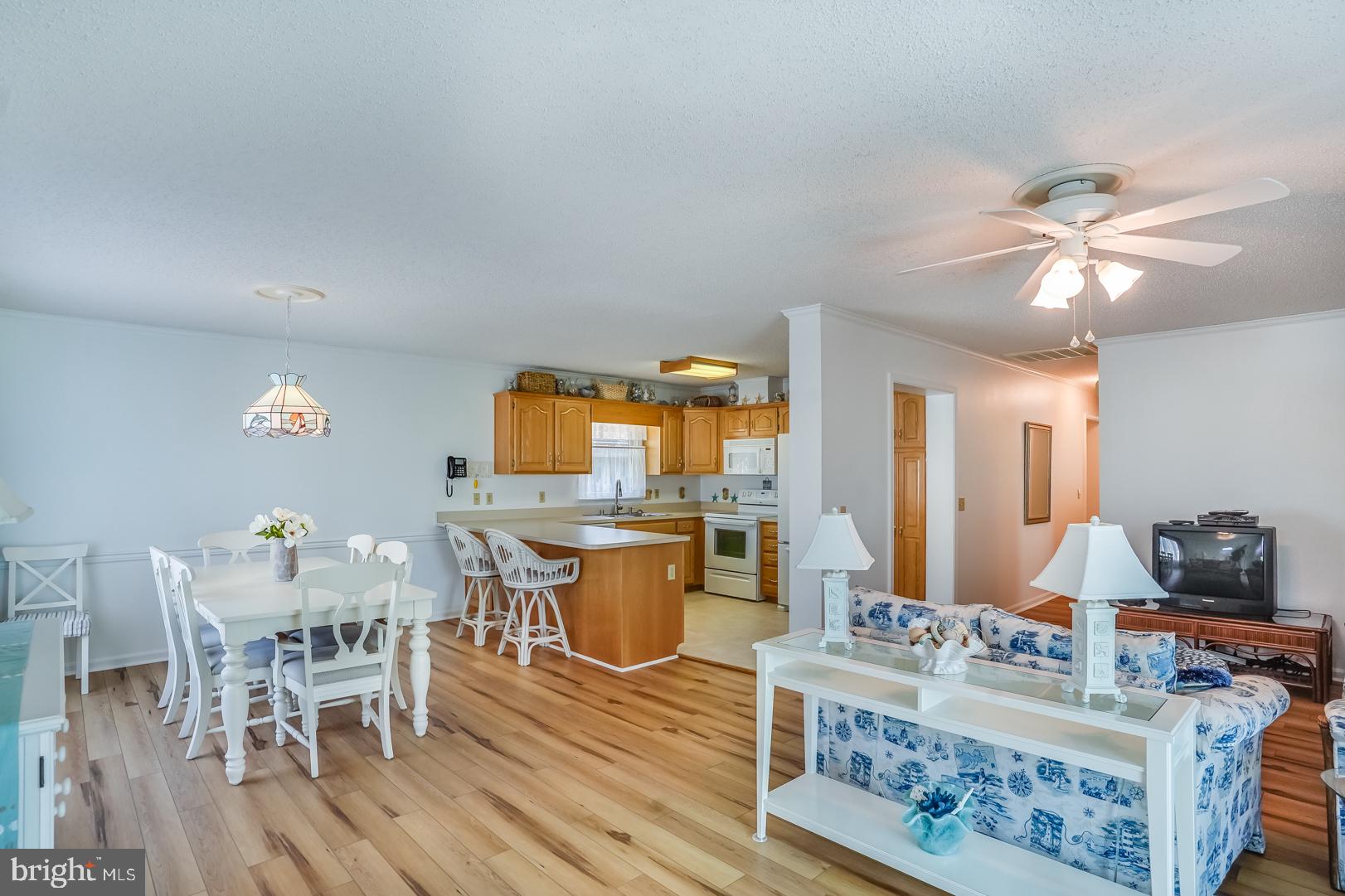13702 Sailing Road Ocean City, MD 21842 - Photo 32 of 32 a view of a dining room with furniture a chandelier and wooden floor