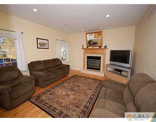 85 Dellwood Road Edison, NJ 08820 - Photo 3 of 8 a living room with furniture a flat screen tv and a fireplace