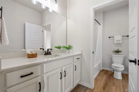a bathroom with a granite countertop sink a toilet and a mirror