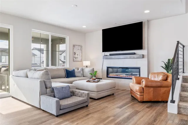 a living room with furniture a flat screen tv and a fireplace