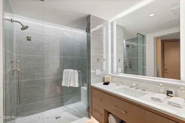 a bathroom with a double vanity sink mirror and shower