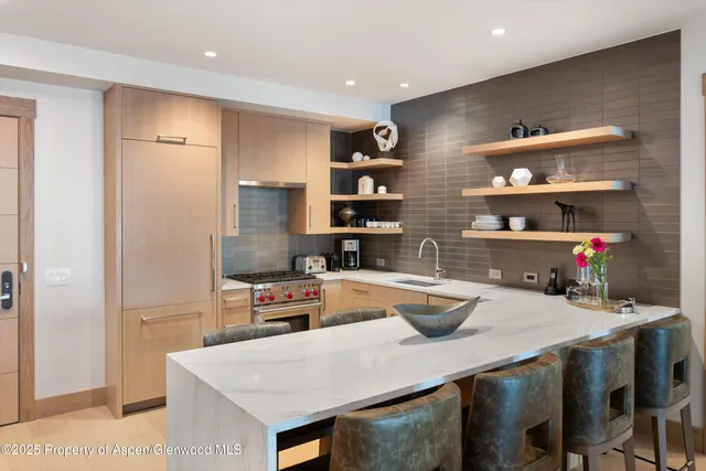 a kitchen with a refrigerator a sink and wooden cabinets