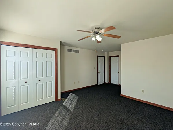 an empty room with a ceiling fan and a window