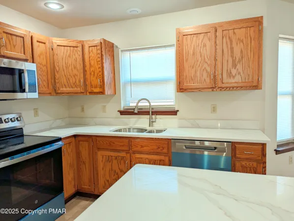 a kitchen with stainless steel appliances granite countertop a sink stove and microwave