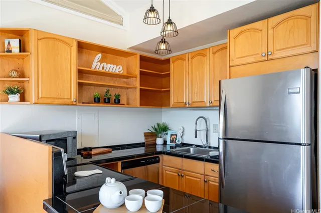 a kitchen with stainless steel appliances granite countertop a sink refrigerator and cabinets