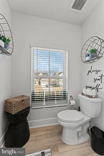 a bathroom with a toilet a sink and a window