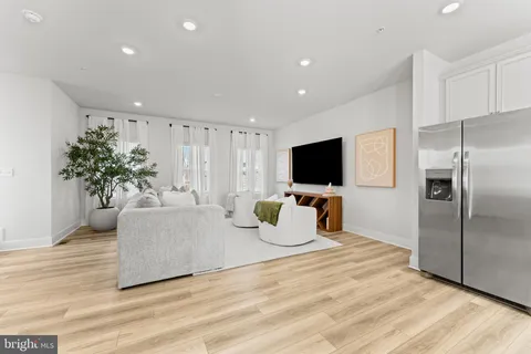 a living room with furniture flat screen tv and potted plant