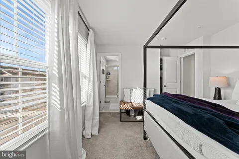 a spacious bedroom with a bed and a large mirror