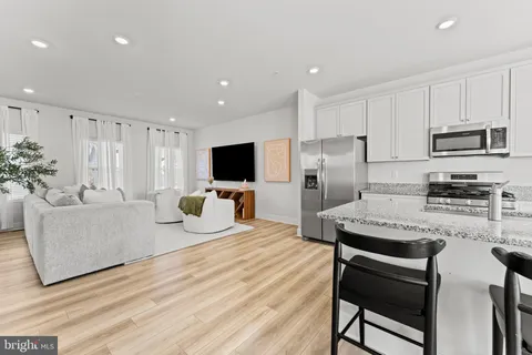 a kitchen with stainless steel appliances kitchen island granite countertop a refrigerator and a stove top oven