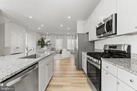 a large kitchen with stainless steel appliances granite countertop a lot of counter space and a sink