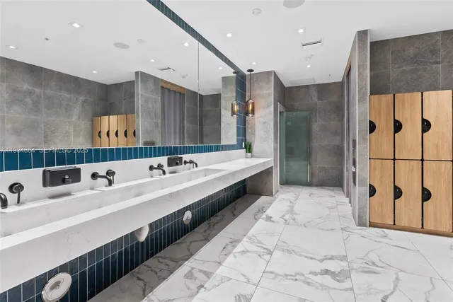 a spacious bathroom with a double vanity sink a large mirror and shower