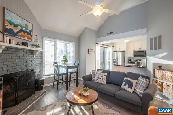 a living room with furniture and a view of kitchen