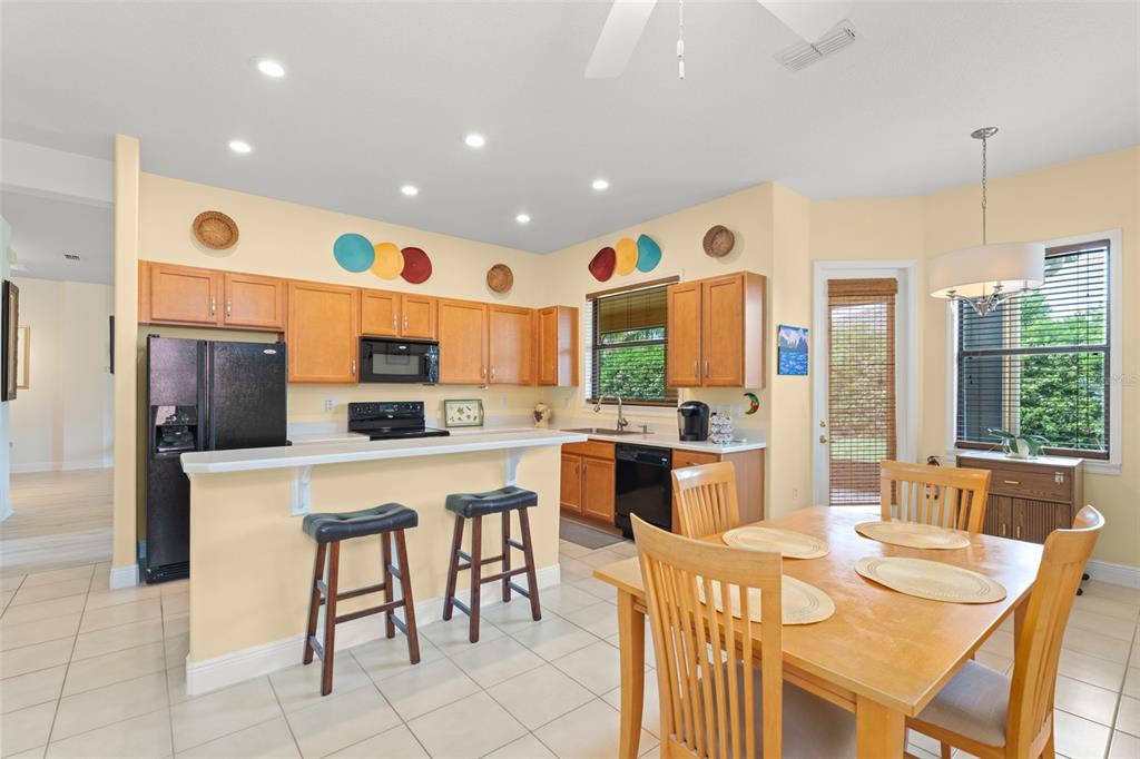 724 Villa Park Road Poinciana, FL 34759 - Photo 13 of 62 a kitchen with stainless steel appliances granite countertop a table chairs and a refrigerator
