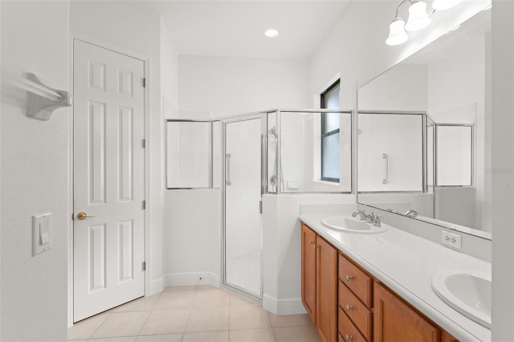 724 Villa Park Road Poinciana, FL 34759 - Photo 21 of 62 a bathroom with a double vanity sink a mirror and a shower
