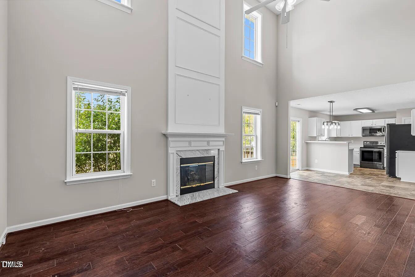 5 Gateview Court Durham, NC 27703 - Photo 13 of 23 an empty room with wooden floor a fireplace and windows