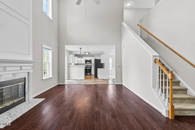 a view of a livingroom with wooden floor and a fireplace