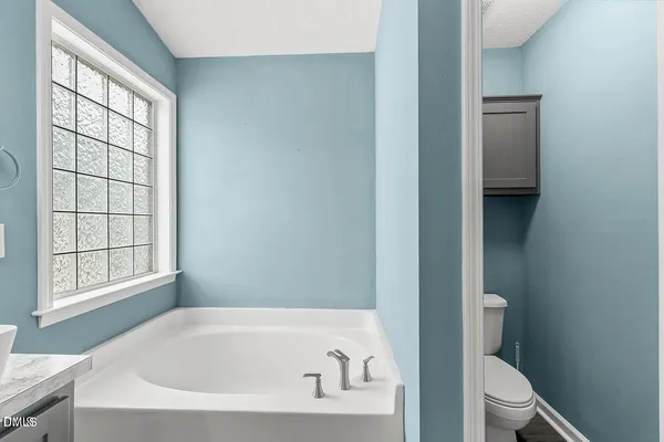 a white bath tub sitting next to a toilet