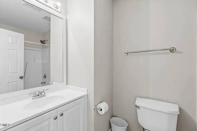 a bathroom with a toilet sink vanity and mirror