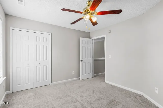 an empty room with chandelier fan