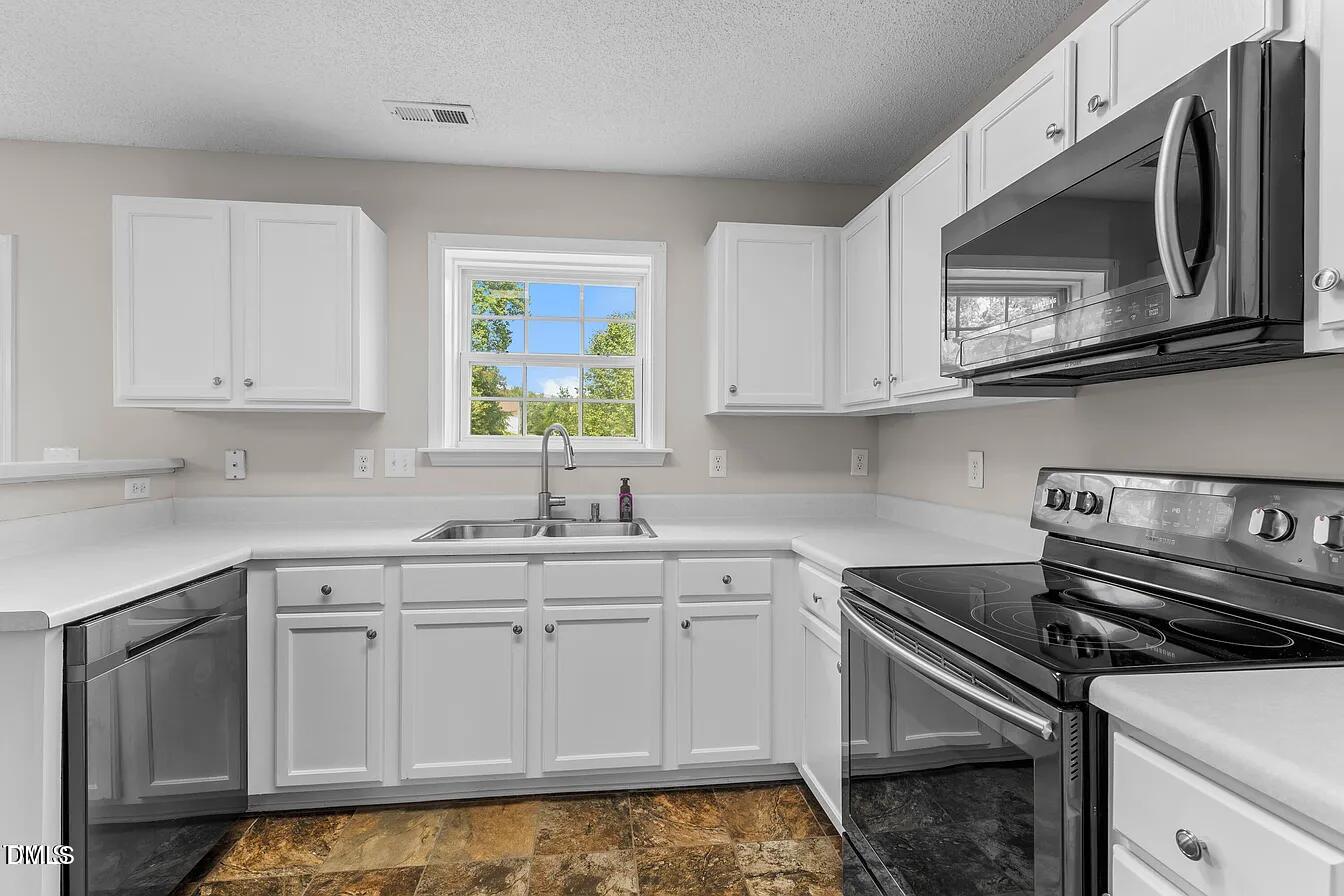 5 Gateview Court Durham, NC 27703 - Photo 7 of 23 a kitchen with stainless steel appliances granite countertop a sink a stove a microwave and cabinets