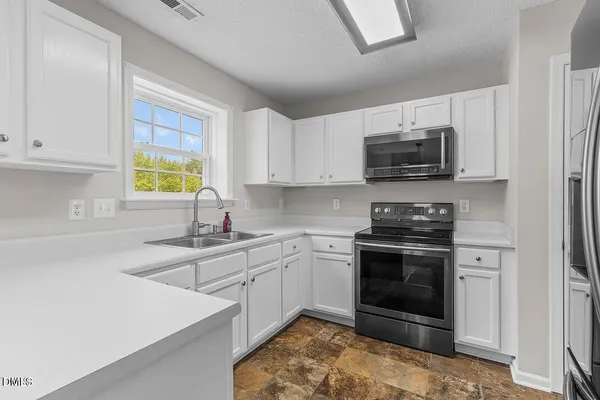 a kitchen with a sink stove and microwave