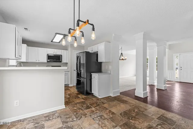 a kitchen view of refrigerator and window